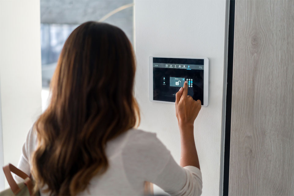 Image of a woman interacting with a home security system