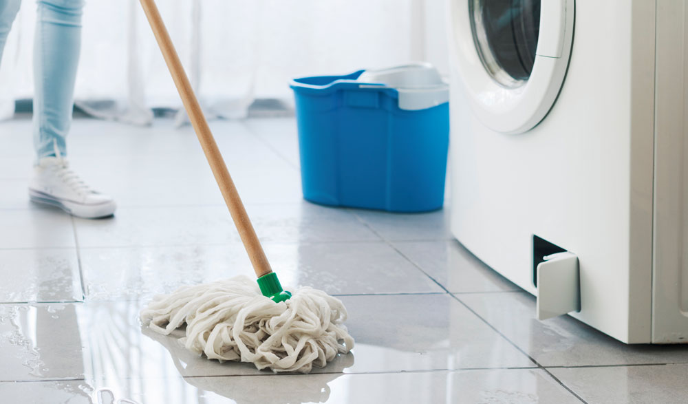 Decorative photo of homeowner mopping a wet kitchen floor