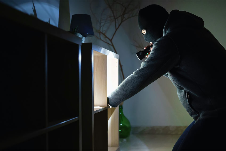 Image of a thief breaking into a home